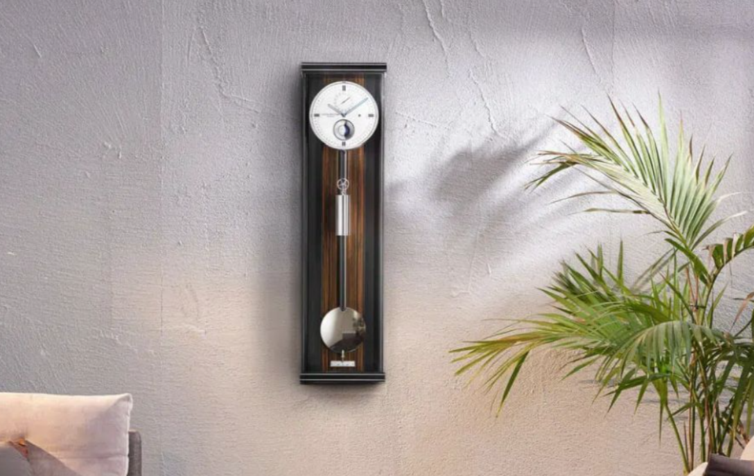 ERWIN SATTLER OPUS PMD 100,
Kast leverbaar in zwart gelakt en in zwartgelakt met Makasar achterwand beide met metaal inleg. 96 cm hoog, 25,5 cm breed en 11 cm diep. Ontspiegeld mineraal glas. Uurwerk Sattler Kaliber 1577. loopduur 30 dagen. 6 Precisie edelstalen kogellagers en 8 Robijn lagers. Geanodiseerde wijzerplaat met handbeschilderde kogel maan en datum aanduiding. Passage slagwerk op rondgong. 